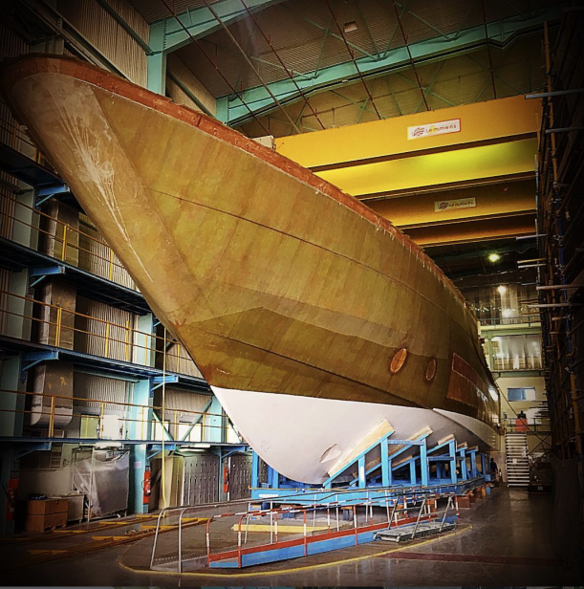 Large yacht hull under construction inside a shipyard